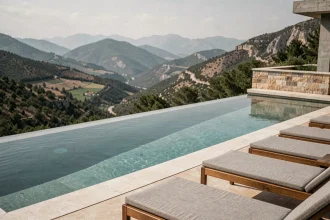 Piscine à débordement intégrée à une villa moderne avec vue panoramique sur la montagne